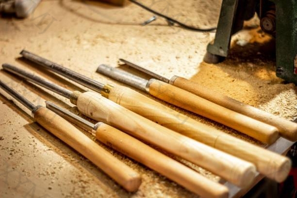 Woodturning tools on a bench surrounded with sawdust.